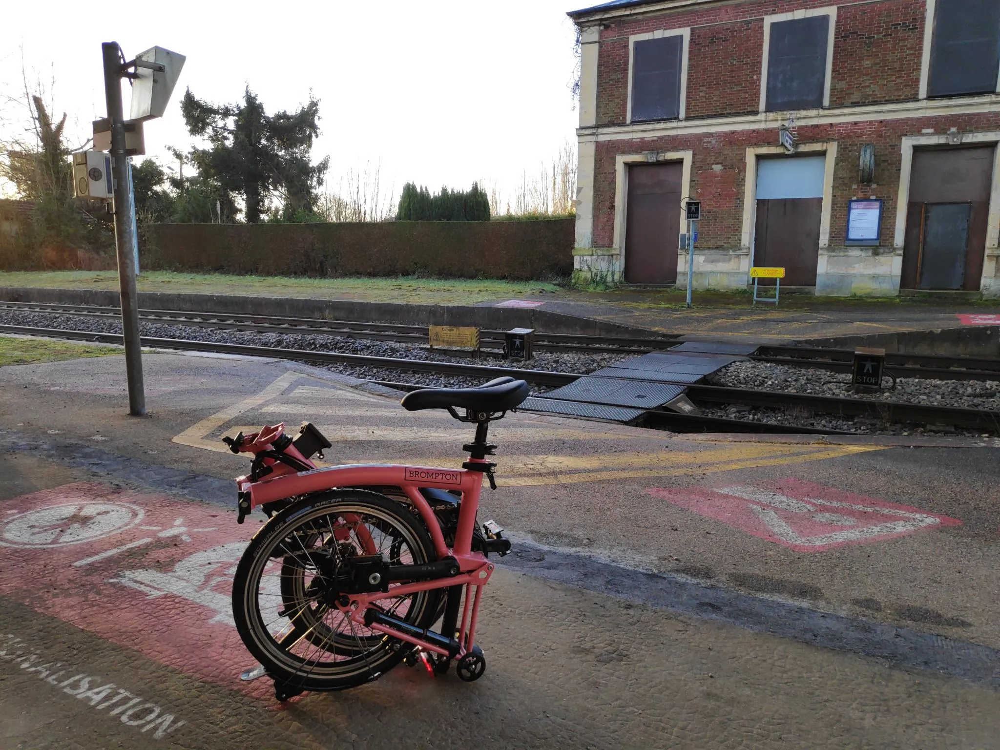 Photographie d'un Brompton C-Line rose replié sur le quai de la gare